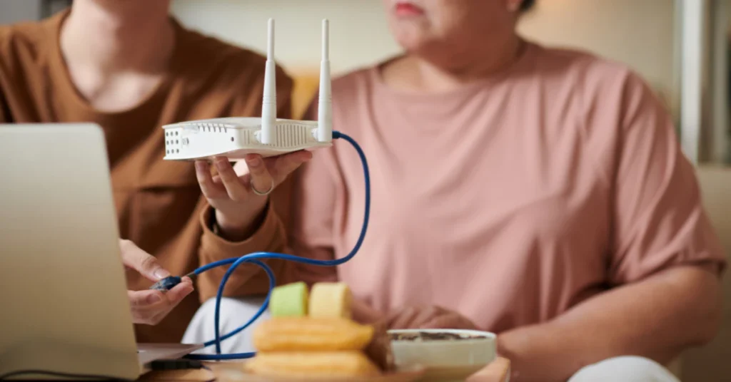 Person checking router settings while connecting a cable to the router