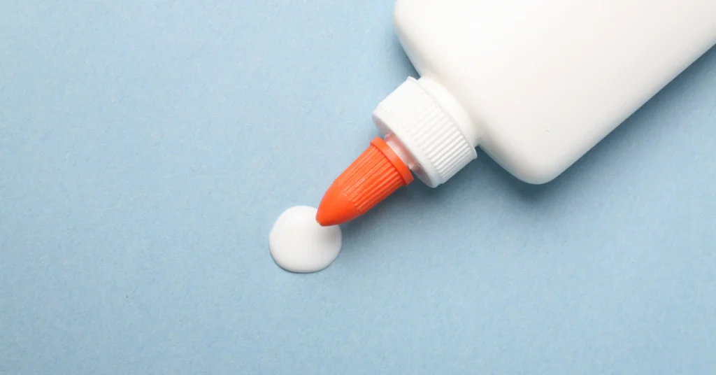 Tube of adhesive remover gel being applied to a light blue surface