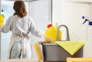 Hands cleaning refrigerator shelves to remove odor