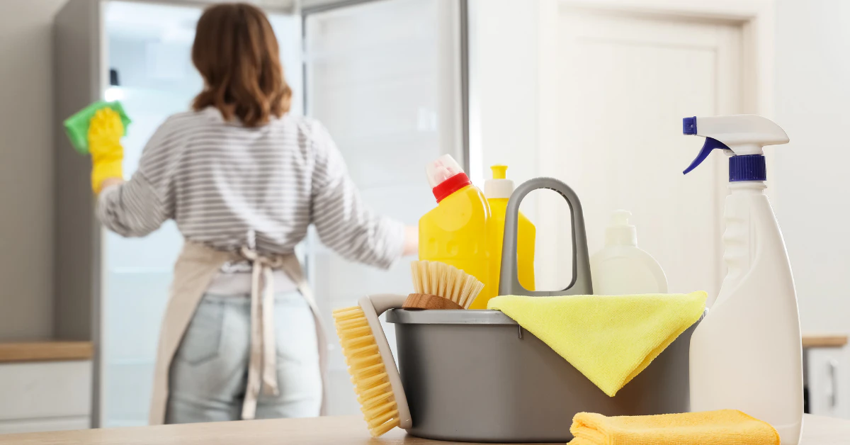 Hands cleaning refrigerator shelves to remove odor