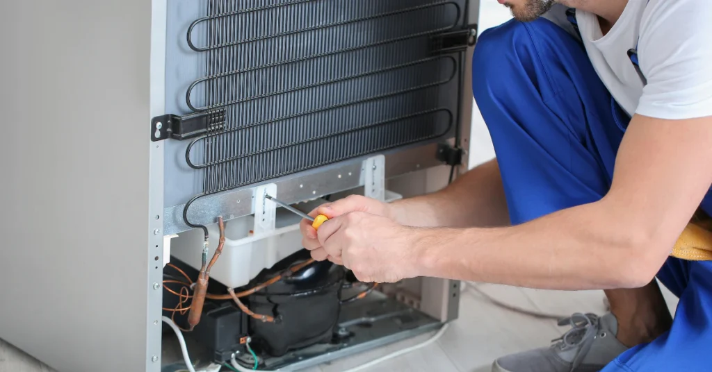 Removing fridge drip pan to check for hidden odor source