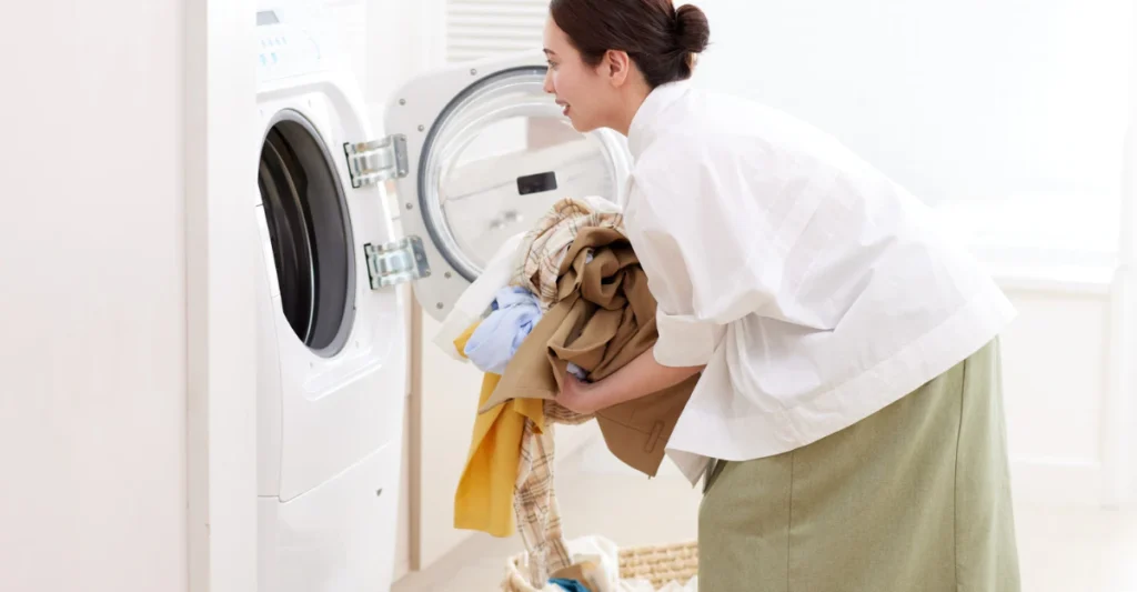 Woman loading a wool sweater into a front-load washing machine