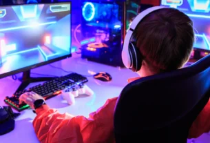 Gamer playing on a gaming monitor setup with purple lighting