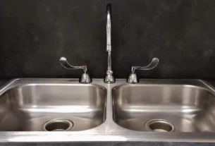 Double-basin stainless steel kitchen sink with a tall faucet