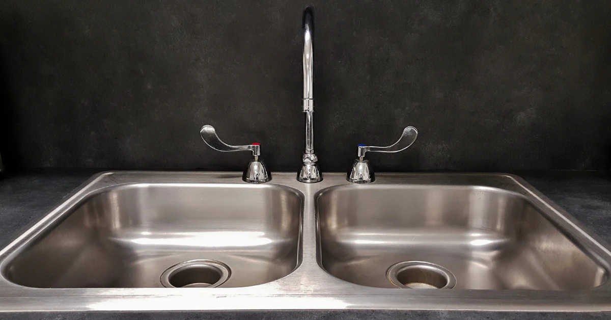 Double-basin stainless steel kitchen sink with a tall faucet