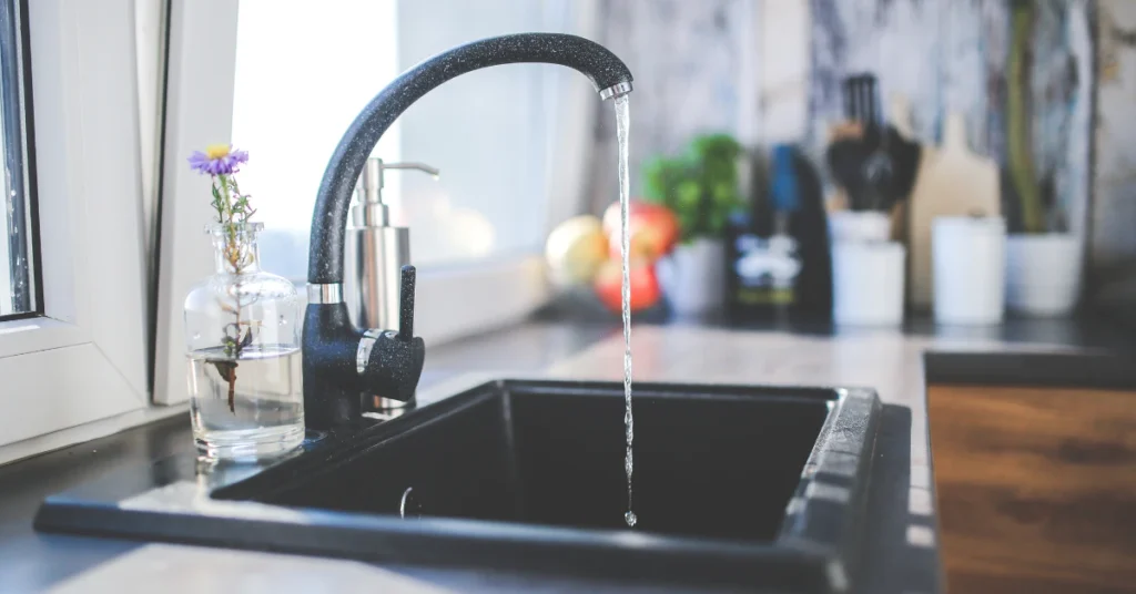 Kitchen faucet running water into a stainless steel sink
