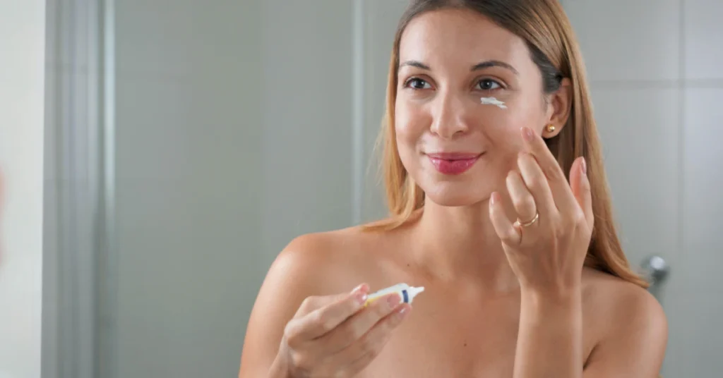 Woman applying cream to her face with her fingertips as part of a skincare routine