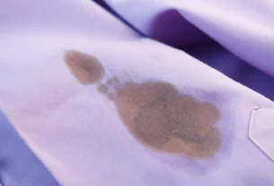 Oil stain on a light purple shirt, showing a grease mark that needs to be removed from clothes