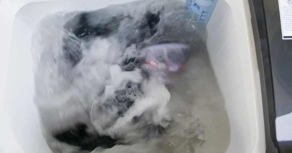 Gray fabric soaking in cool soapy water in a tub