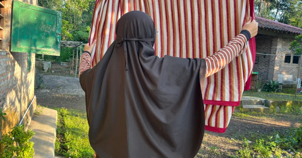 Woman standing outdoors next to laundry hung up to dry