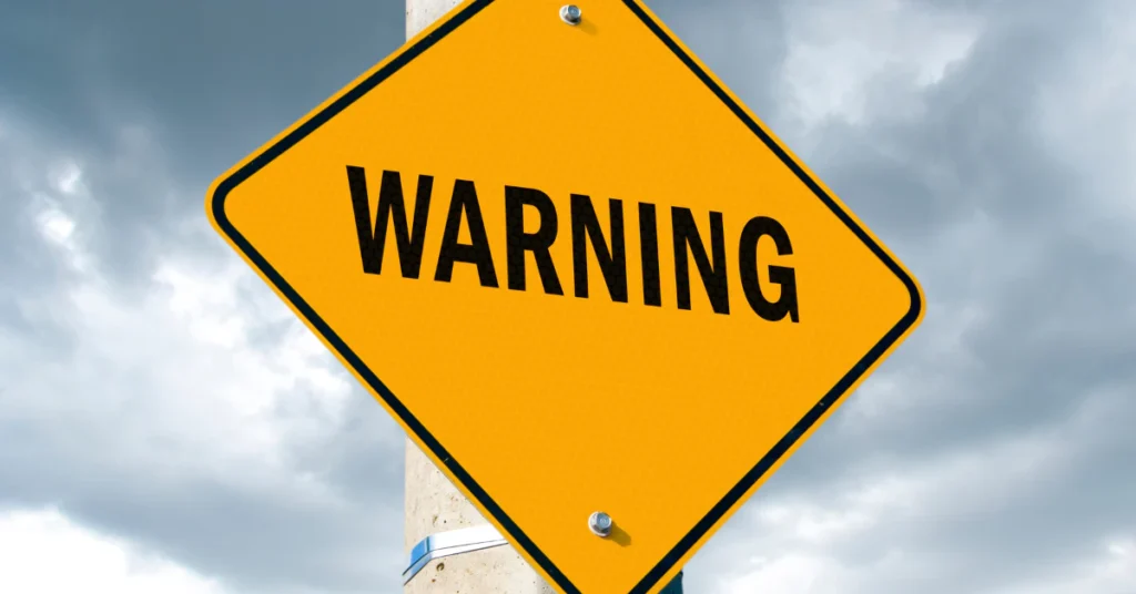 Yellow diamond warning sign against a blue sky, highlighting the safety risks of smelling salts